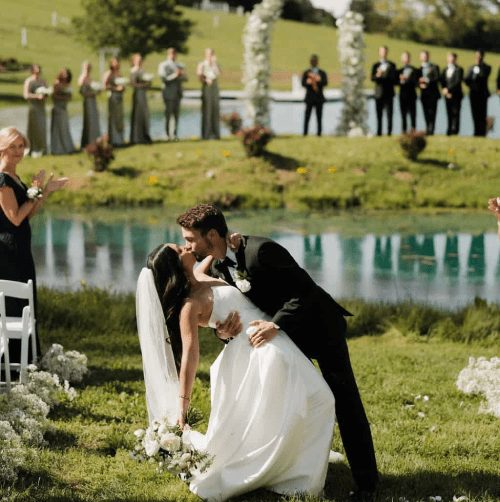 Lakeside ceremony with white chairs at Cedar Pond Farms
