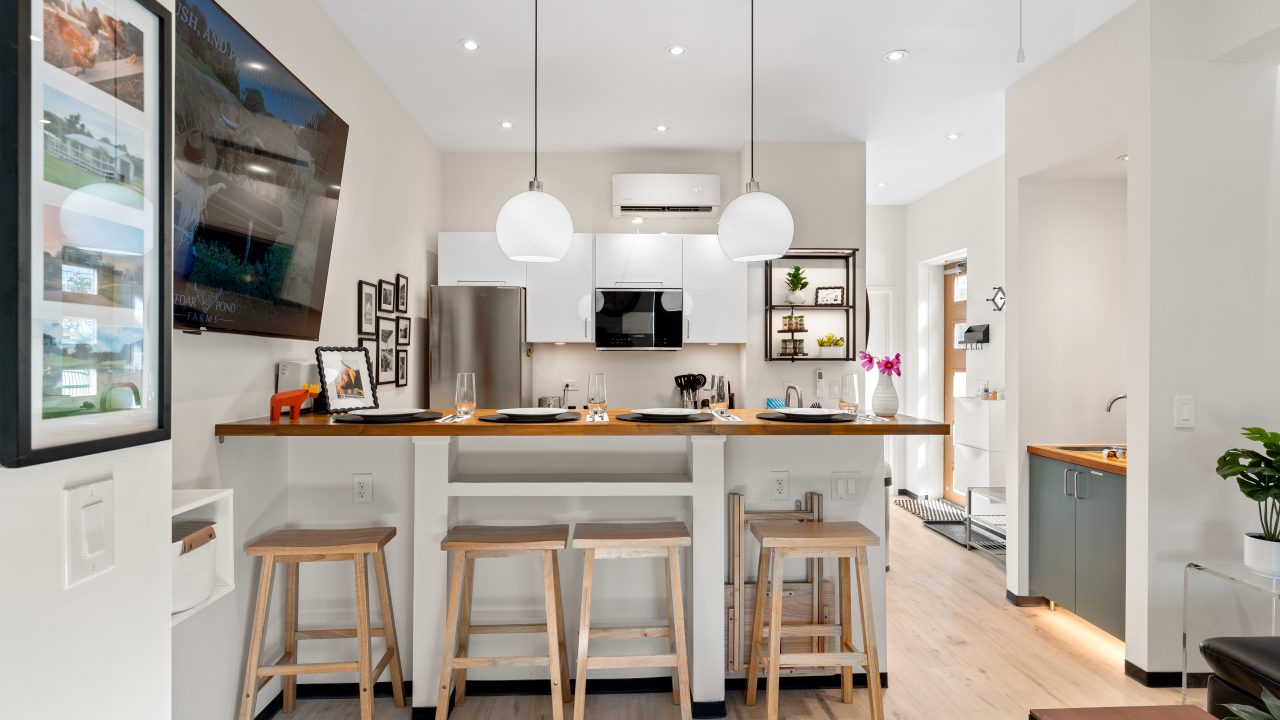 The open kitchen and breakfast bar of a Cedar Pond Farms barndominium farm stay, set for four.
