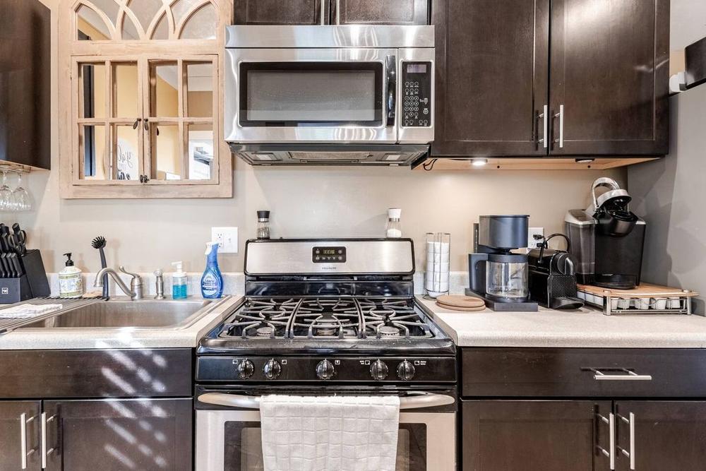 A farm kitchen with a gas range, drip coffee maker and espresso machine on the counter