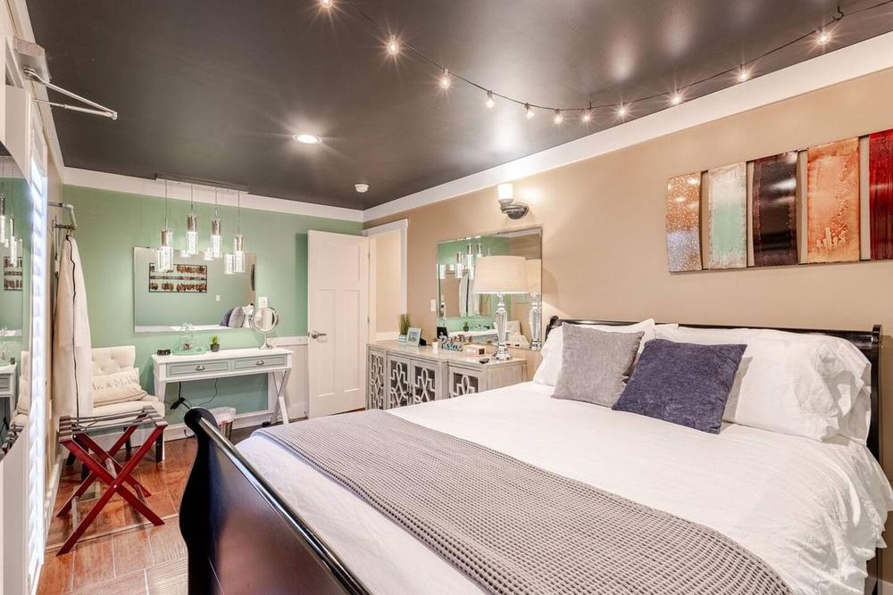Second Milkbarn ready room with vanity, sage walls, and string-light ceiling
