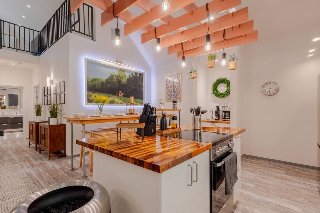 Cook beneath the coral beams and filament lights in this three-bedroom barndominium kitchen at Cedar Pond Farms, just outside the Smoky Mountains.