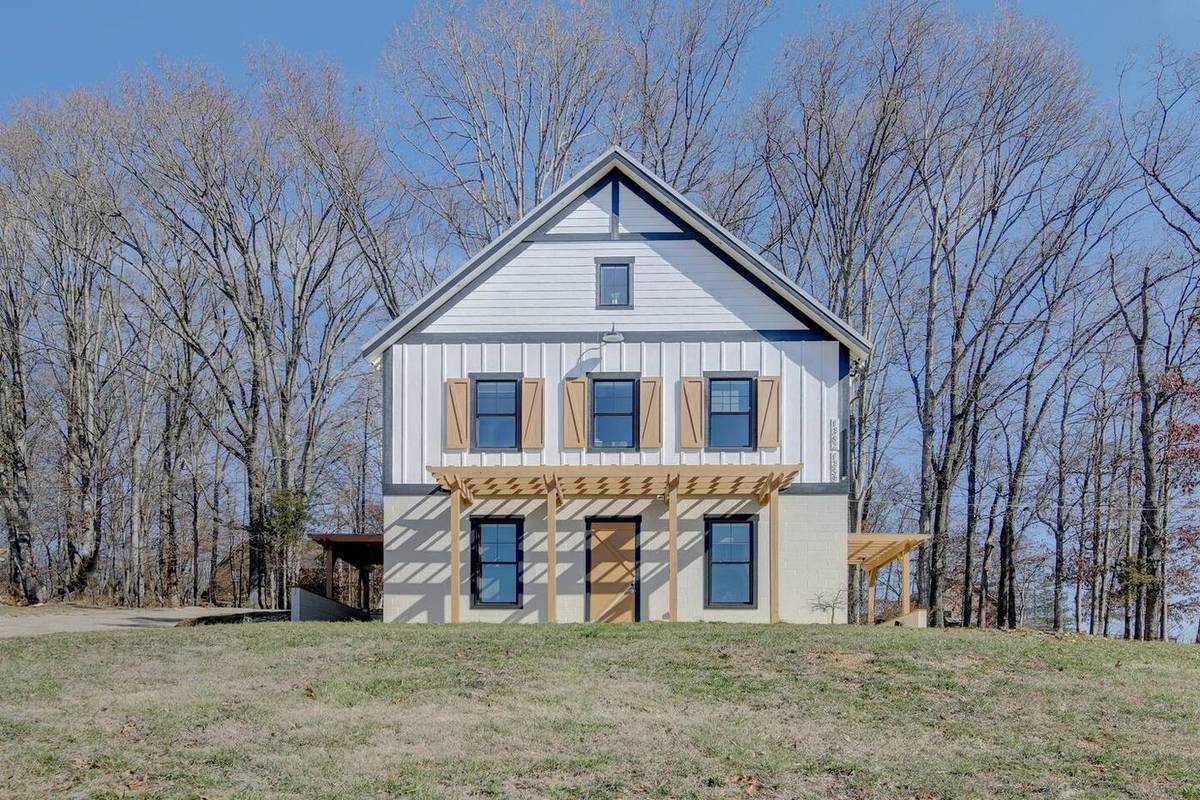 Board-and-batten barndominium buildings around the pasture at Cedar Pond Farms, the farm stay ten miles from River Glen Equestrian Park