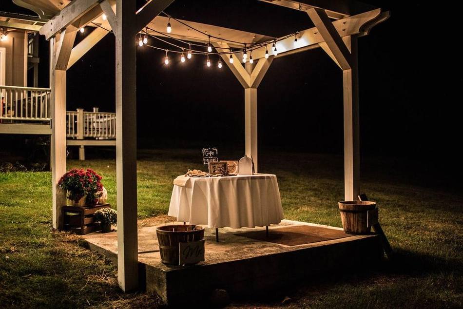 The Main Stage pergola at Cedar Pond Farms, framed by mature trees, set for a ceremony